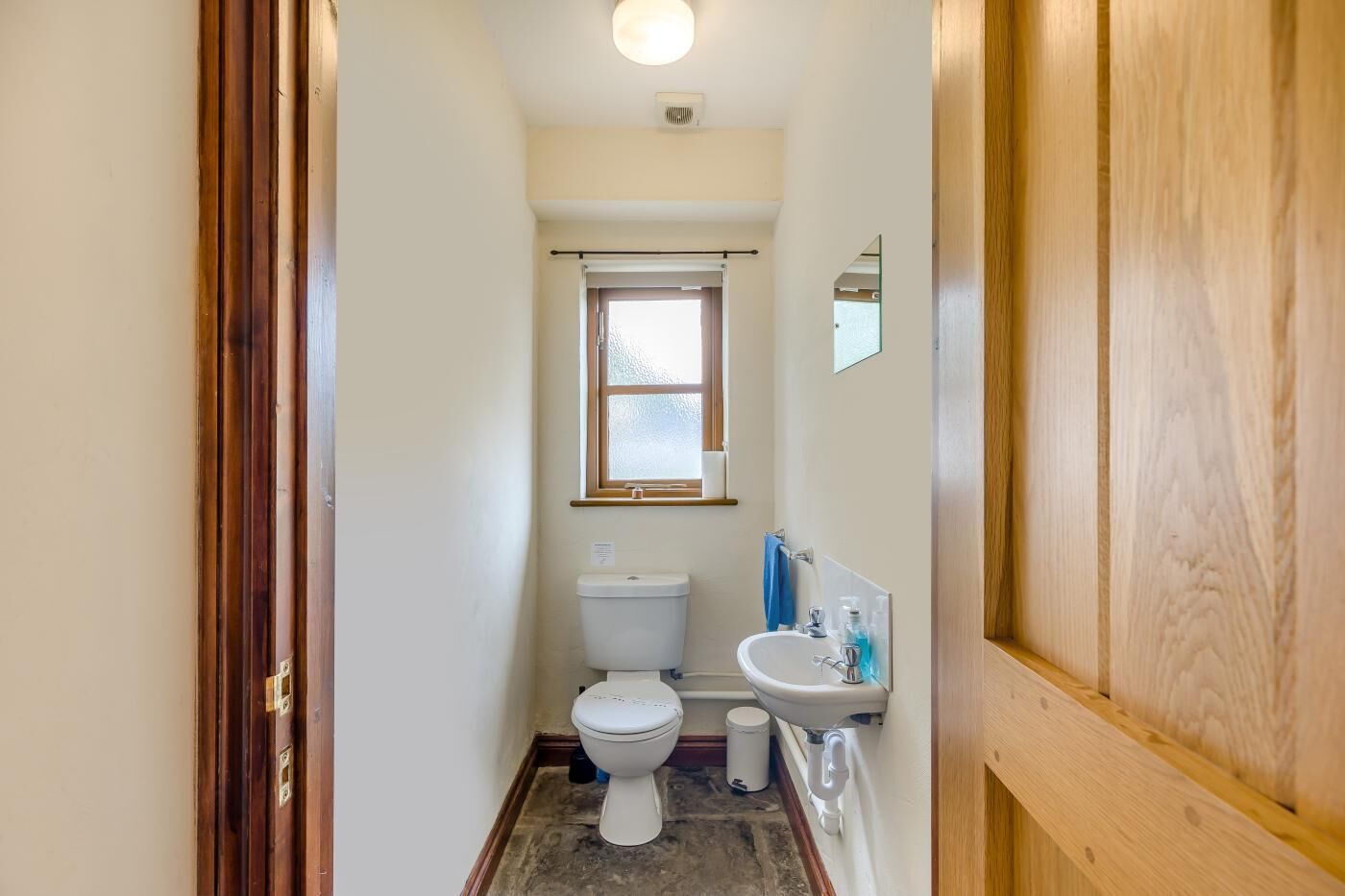 Une petite salle de bain comprenant des toilettes, un lavabo et une fenêtre.