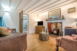 A cozy living room with a fireplace, wooden furniture, and a television.