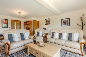 A living room with two sofas, a coffee table, and framed pictures on the wall. - 3 Bed in Aberdyfi (oc-54035) (Pennal)