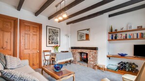 Ein gemütliches Wohnzimmer mit Kamin, Holzmöbeln und einer B ücherwand.