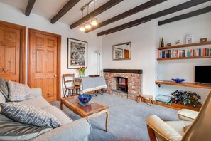 A cozy living room with a fireplace, wooden furniture, and a bookshelf. - 1 Bed in Whitby (oc-w1025) (Whitby)