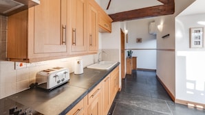 Eine moderne Küche mit Holzschnitzereien, einem eingebauten Toaster und einem Spülbecken.