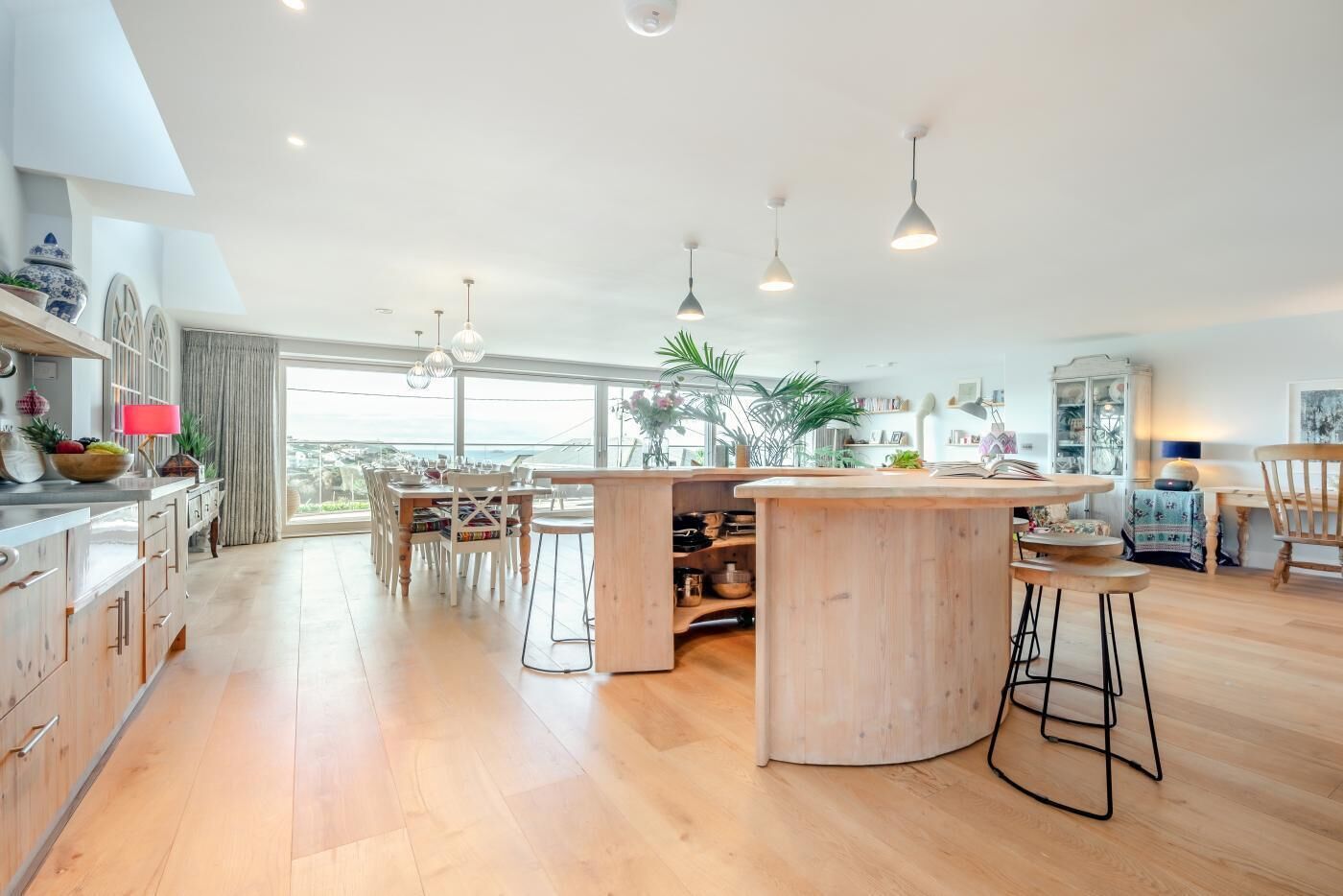 A spacious kitchen with a central island, wooden cabinets, and pendant lighting.