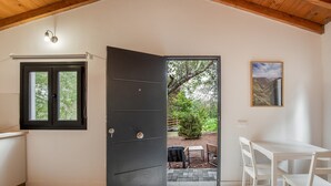 A room with a black door, a window, a table, and chairs. - Vacation Apartment '6' with Mountain View, Shared Terrace and Garden (Moya)