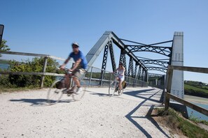 A metal bridge with a dirt path for bicycles.