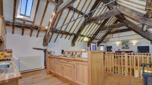 A rustic kitchen with exposed beams, a wooden island, and a view of the upper level. - 2 Bed in Machynlleth (oc-197758) (Machynlleth)