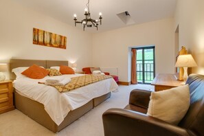 Una camera da letto con un letto grande, un lampadario, un quadro, una finestra vista e una poltrona in pelle.