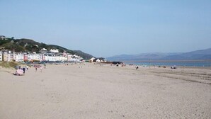 Una amplia playa de arena con edificios al fondo.