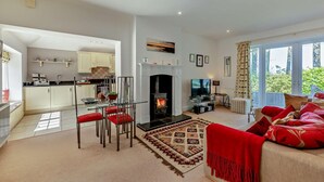 A modern living room with a fireplace, a dining area, and a kitchen. - 1 Bed in Embleton (oc-566732) (Embleton)