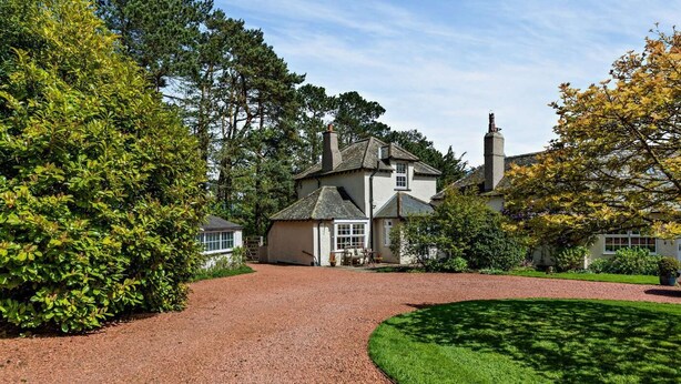 A large house with a gravel driveway and a well-maintained lawn. - 1 Bed in Embleton (oc-566732) (Embleton)