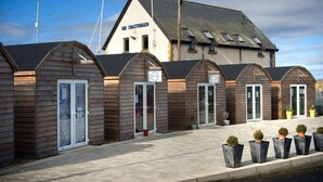 Een kustverblijf met houten hutten en een groot gebouw met de tekst 
