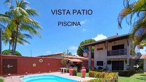 Area piscina con vista, circondata da palme e un edificio.