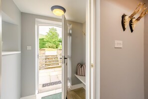 A hallway with a door leading to an outdoor area, a light fixture, and wall-mounted decor. - 3 Bed in Barbon (oc-b33652) (Barbon)
