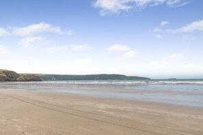 Ein Strand mit sandigem Ufer und Blick auf den Ozean.