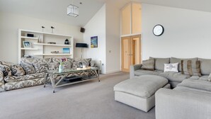 A living room with a sofa, a coffee table, and a bookshelf. - 4 Bed in Beadnell (oc-566397) (Beadnell)