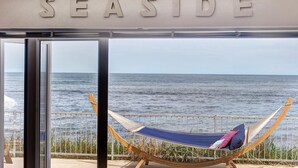 A hammock with pillows on a balcony overlooking the sea, with a sign reading "SEASIDE". - 4 Bed in Beadnell (oc-566397) (Beadnell)