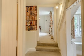 A staircase leading to a room with a bookshelf, a door with a curtain, and a light fixture. - 3 Bed in Calbourne (oc-g33538) (Calbourne)