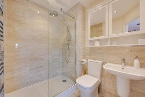 A modern bathroom with a glass-enclosed shower, a white toilet, and a sink with a mirror above. - 2 Bed in Seahouses (oc-565751) (Seahouses)