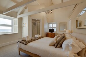 A bedroom with a large bed, a television on a dresser, a shower, and a window with blinds. - 3 Bed in Craster (oc-566727) (Dunstan)