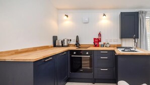 A compact kitchen with a built-in oven, a coffee maker, and a toaster. - 1 Bed in Sheringham (oc-n33618) (Sheringham)