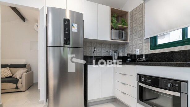 A modern kitchen with stainless steel appliances, white cabinetry, and a built-in oven. - Lobie Vilares Copacabana (Rio de Janeiro)