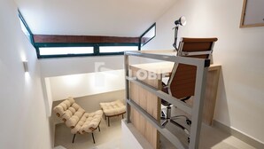 A modern loft bedroom with a bunk bed, a desk with a chair, and a cushioned bench. - Lobie Vilares Copacabana (Rio de Janeiro)