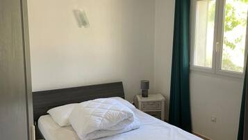 Tabla de planchar con plancha y ropa de cama