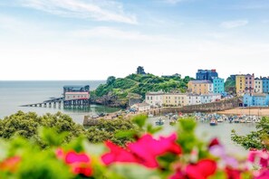 A coastal town with colorful buildings, a pier, and boats in the harbor.