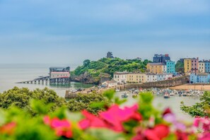 A coastal town with colorful buildings, a pier, and boats in the harbor.