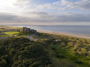A coastal landscape with a historic castle overlooking a beach. - 2 Bed in Bamburgh (oc-nb1969) (Bamburgh)