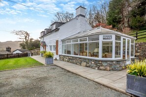 A house with a stone foundation, a white exterior, and a bay window. - 3 Bed in Dolgellau (oc-203224) (Llanelltyd)
