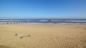 A beach with a clear sky, a sandy shore, and a few rocks. - 2 Bed in Hickling (oc-1794) (Hickling)