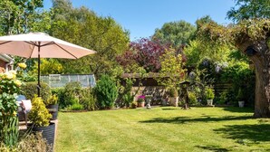A well-maintained garden with a patio area, a pergola, and various potted plants. - 2 Bed in Hickling (oc-1794) (Hickling)