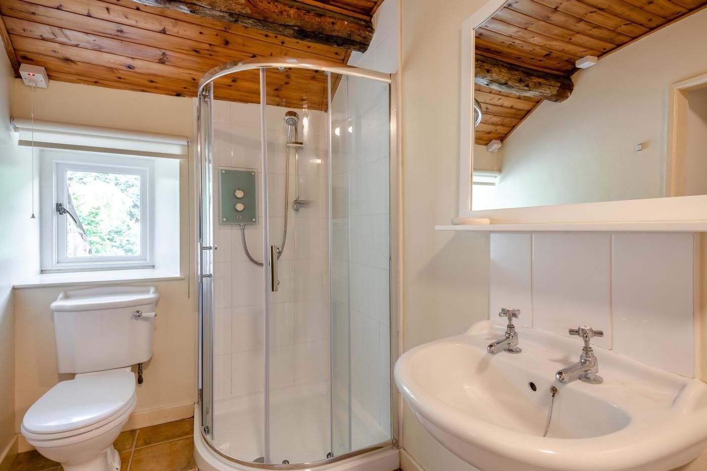 Une salle de bain équipée d’une douche, de toilettes, d’un lavabo et d’une fenêtre.