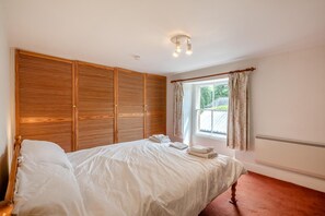 A bedroom with a bed, wooden wardrobe, window with curtains, and a ceiling light fixture. - 2 Bed in Pooley Bridge (oc-r33740) (Pooley Bridge)