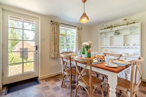 A dining area with a table set for breakfast, a hanging light fixture, and a view of the outside. - 3 Bed in Dunwich (oc-atc2) (Dunwich)