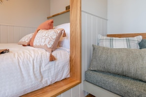 A bedroom with a bed, a wooden headboard, and a grey sofa. - 1 Bed in Hawton (oc-d33741) (Hawton)