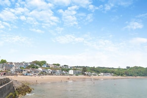 Eine Küstenstadt mit einem Sandstrand, Häusern entlang der Küste und einem klaren Himmel.