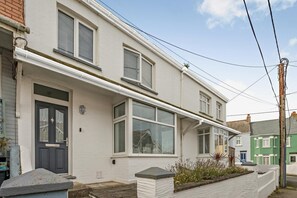 A two-story residential building with a white facade, a dark front door, and multiple windows with shutters. - 3 Bed in Padstow (oc-f33036) (Padstow)
