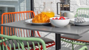 A table with breakfast items, a coffee maker, and a glass of orange juice against a white brick wall. - 2 Bed in Southwold (oc-brec) (Southwold)