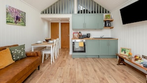 A compact living space with a dining area, kitchenette, and a loft bedroom. - 2 Bed in Mouswald (oc-b33444) (Mouswald)