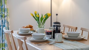 A dining table set with plates, bowls, a coffee pot, and a jar of jam. - 2 Bed in Bath (oc-bhr44) (Bath)