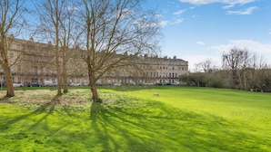 A grassy field with trees and a building in the background. - 2 Bed in Bath (oc-bhr44) (Bath)