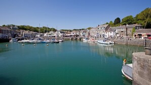 A harbor with boats docked, buildings along the waterfront, and a clear blue sky. - 4 Bed in Little Petherick (oc-urchpe) (Little Petherick)