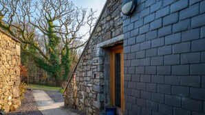 A stone building with a wooden door and a small window. - 2 Bed in Dolgellau (oc-bow282) (Blaenau Ffestiniog)