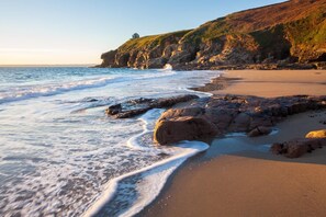 A beach with rocky formations and a clear sky. - 1 Bed in Rinsey (oc-1chapl) (Ashton)