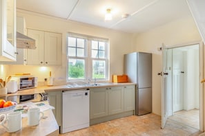 A kitchen with a dishwasher, a refrigerator, a window, and a door leading to another room. - 3 Bed in Sennen (oc-cpz56) (Sennen)