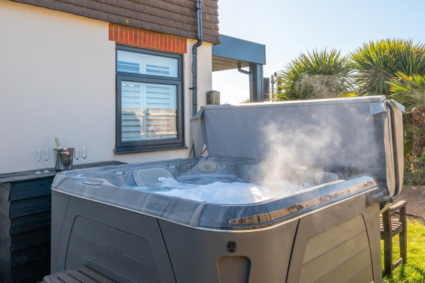 Un bain à remous installé à l’extérieur, avec une maison en arrière-plan.