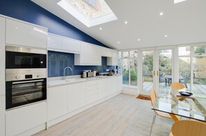 Een oven, een vaatwasser, kookgerei, borden en bestek