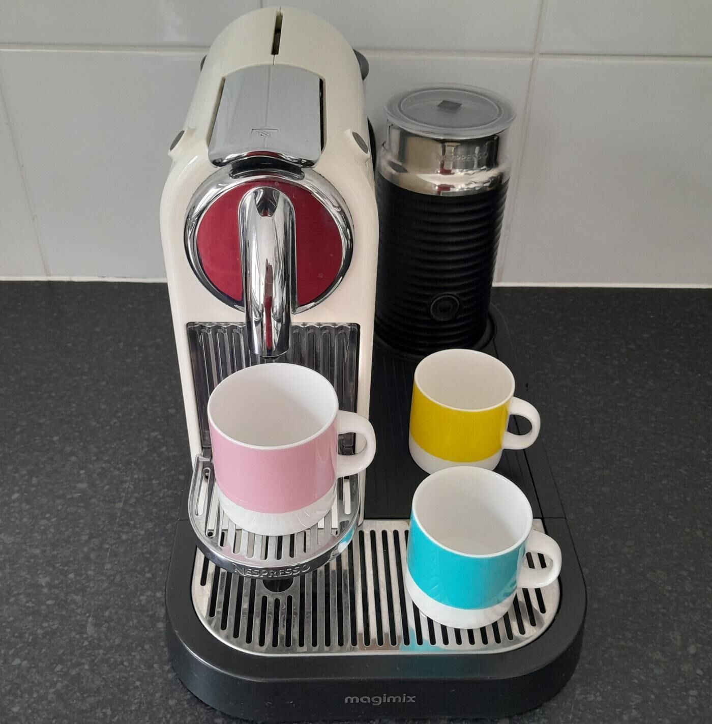 A Nespresso coffee machine with two cups on its drip tray.